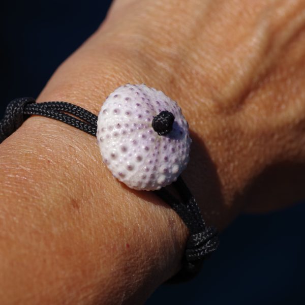 bracelet avec un oursin blanc et une cordelette marine noire nouée