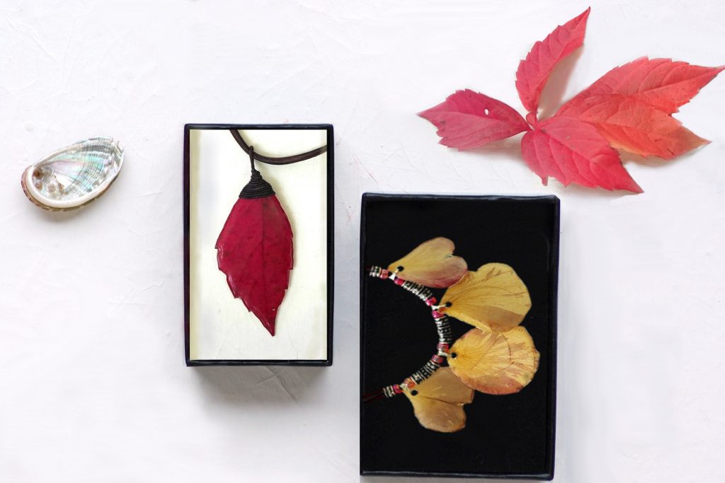 bijoux végétaux dans des écrins et un joli décor autour (coquillage, feuilles rouges)