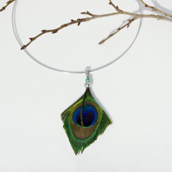Le pendentif est une belle plume de paon coupée en pointe aux couleurs magnifiques : bleu, vert et mordoré à reflets brillants. Le tour de cou rigide en inox.