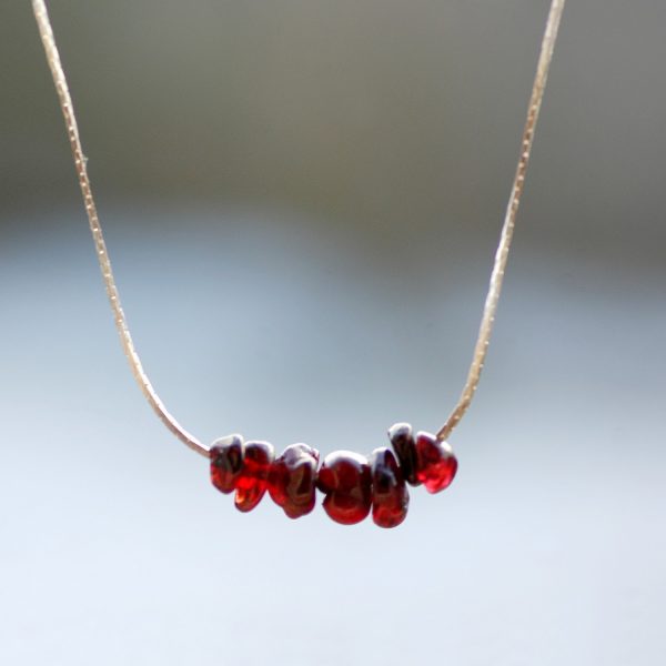 collier minimaliste : Quelques pierres gemmes grenats enfilées sur une très fine chaîne serpentine argentée.