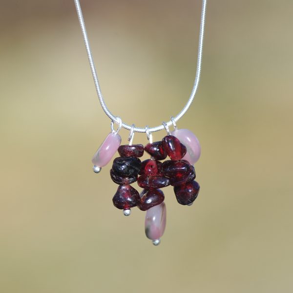 Fine chaîne serpentine avec un pendentif gemmes.Grenats presque bruts et des perles d'opales roses.