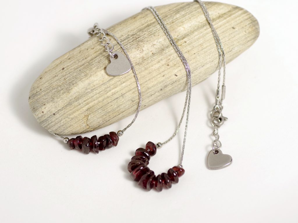 parure collier et bracelet, chaînes en inox, perles de pierres grenats et coeur en inox.