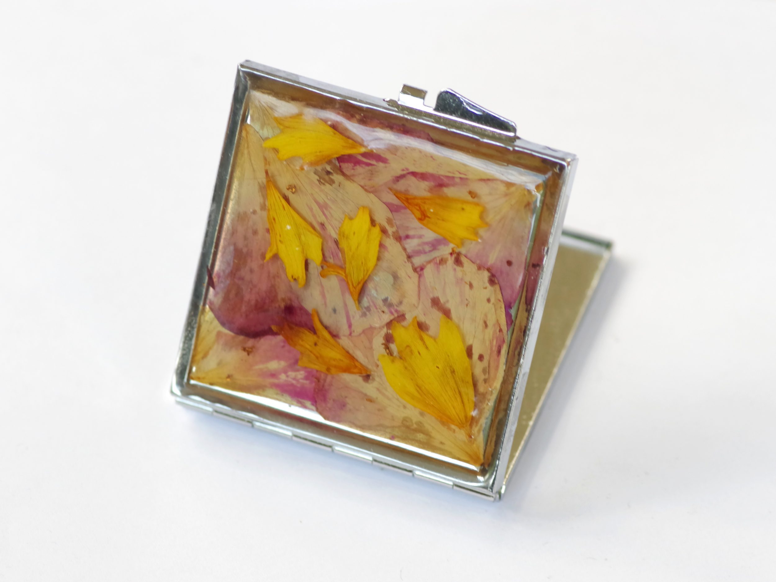 miroir de poche décoré d'un mélimélo de pétales roses et jaunes protégés par de la résine