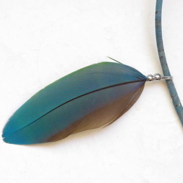 belle plume de perroquet blleu-vert en pendentif sur un collier bleu-vert en liège