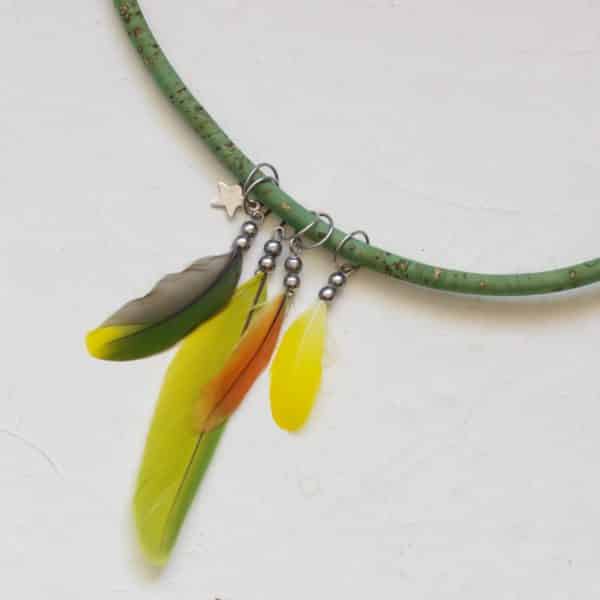 collier multicolore avec quatre pendentfs en plumes (jaune, verte, orange) et un petit pendentif étoile. Le tuur de cou est en liège vert
