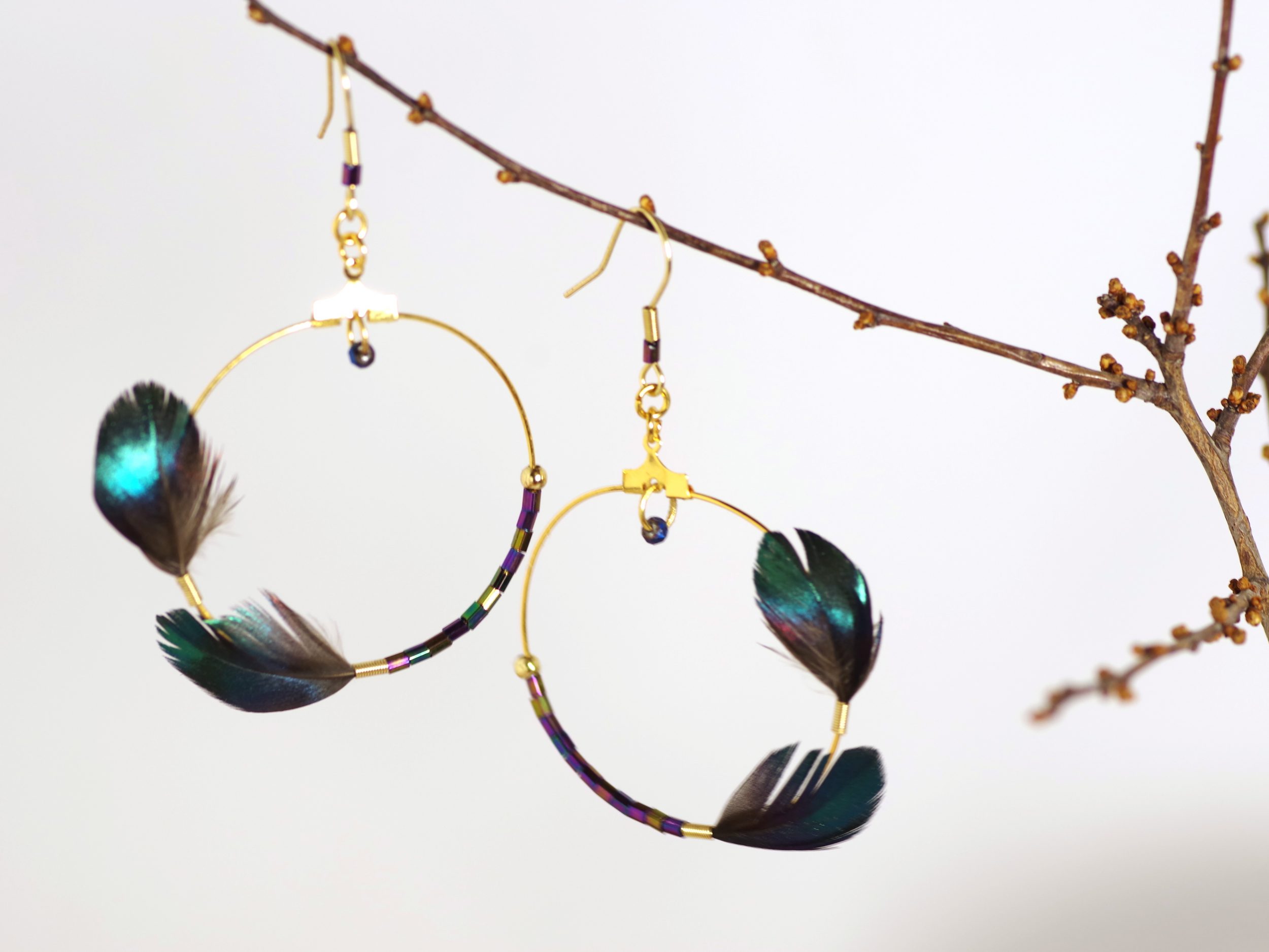boucles d'oreilles avec un grand anneau doré asymétrique, décoré d'un côté avec deux plumes et de l'autre avec des perles de verre assorties (très petites)
