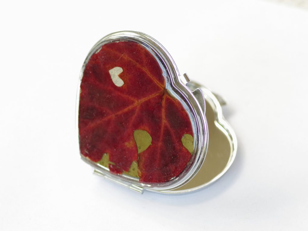 miroir de poche en forme de coeur décoré d'une très belle feuille de vigne rouge avec une petite échancrure naturelle en forme de petit coeur