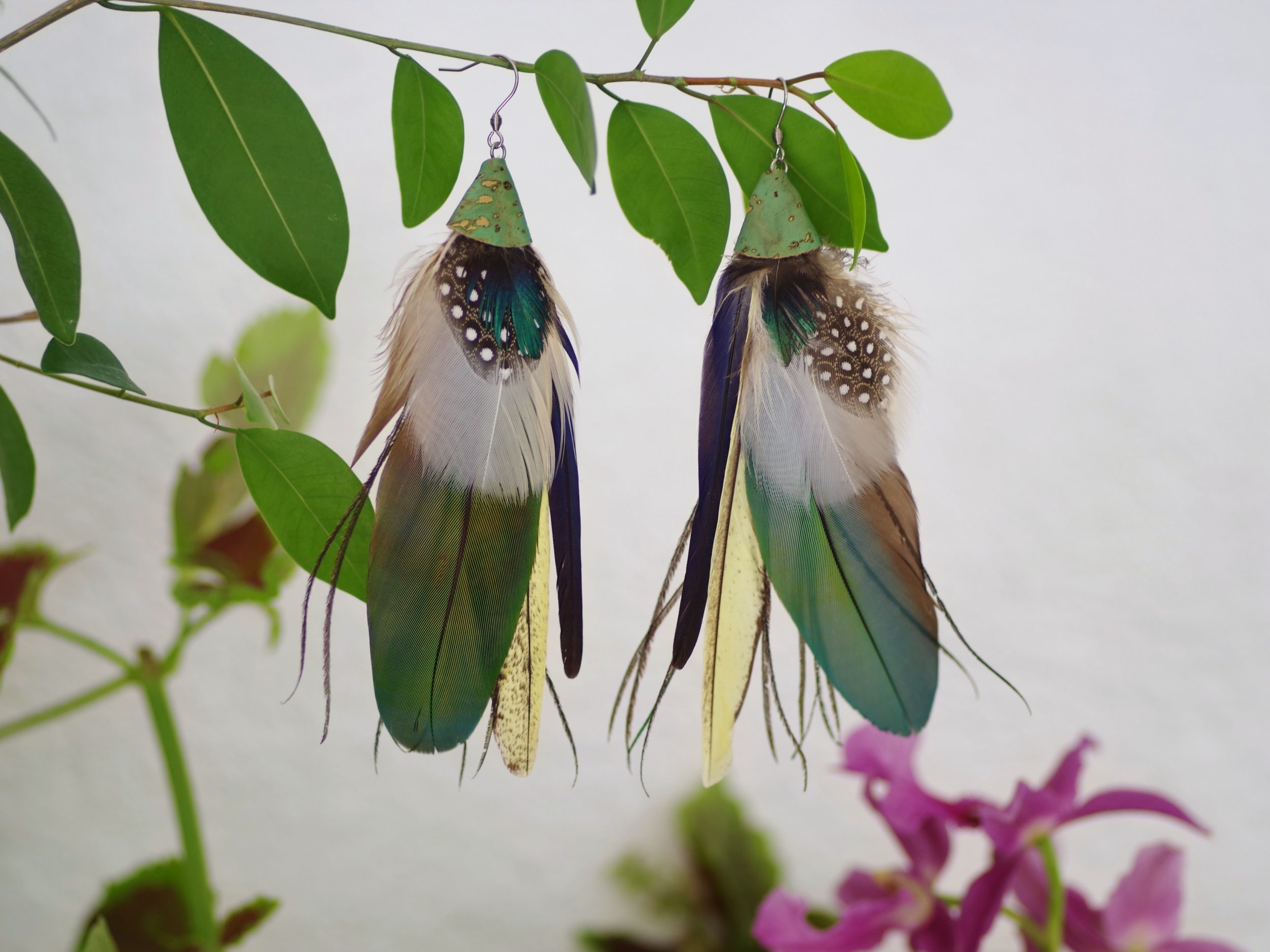 grandes boucles d'oreilles avec une composition de plumes dans des à dominante bleu-vert et blanc