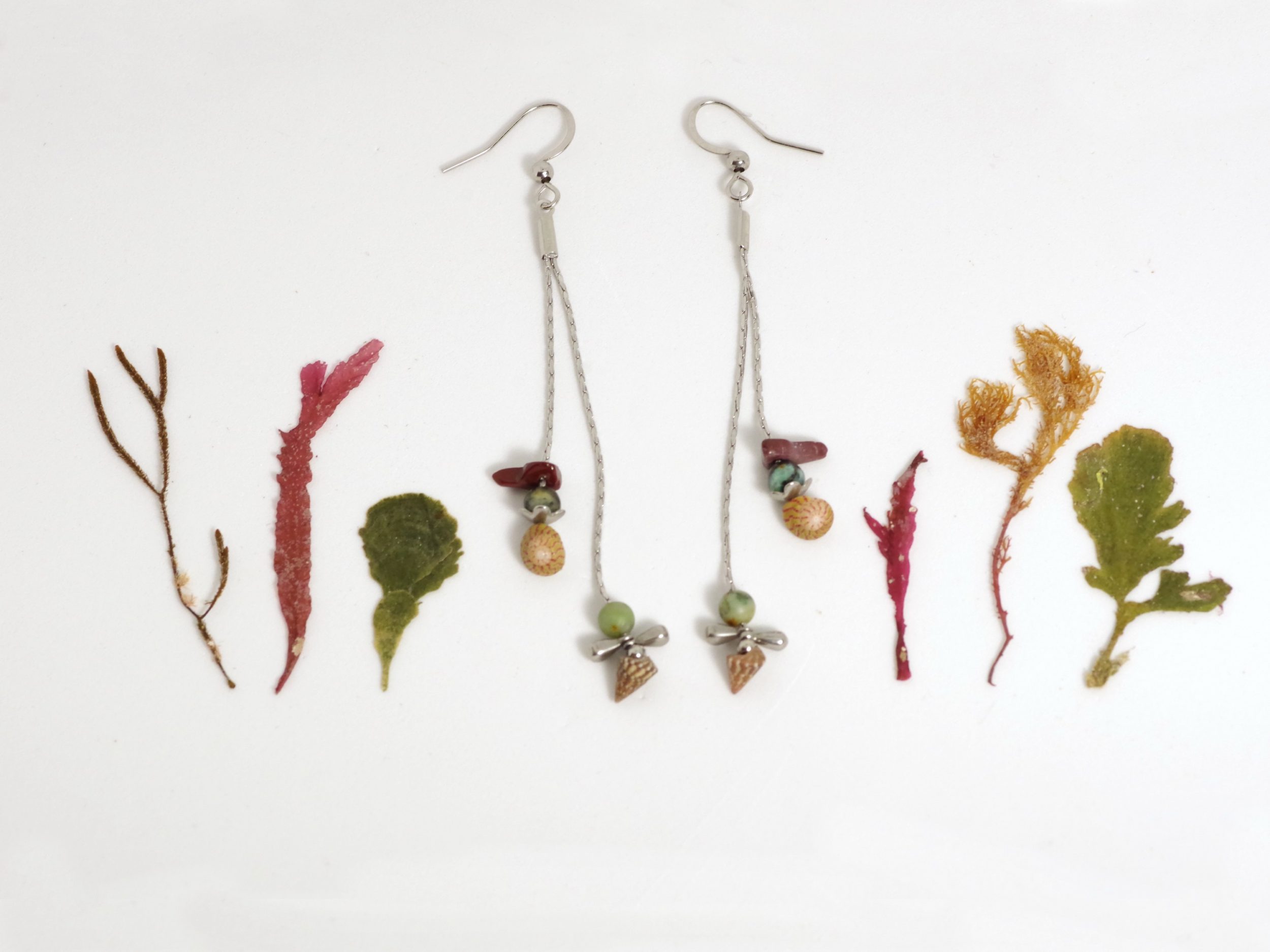 Boucles d'oreilles avec gemmes et coquillages de couleur brun brique et turquoise sur de fines chaînes en iinox, look épuré, style minimaliste