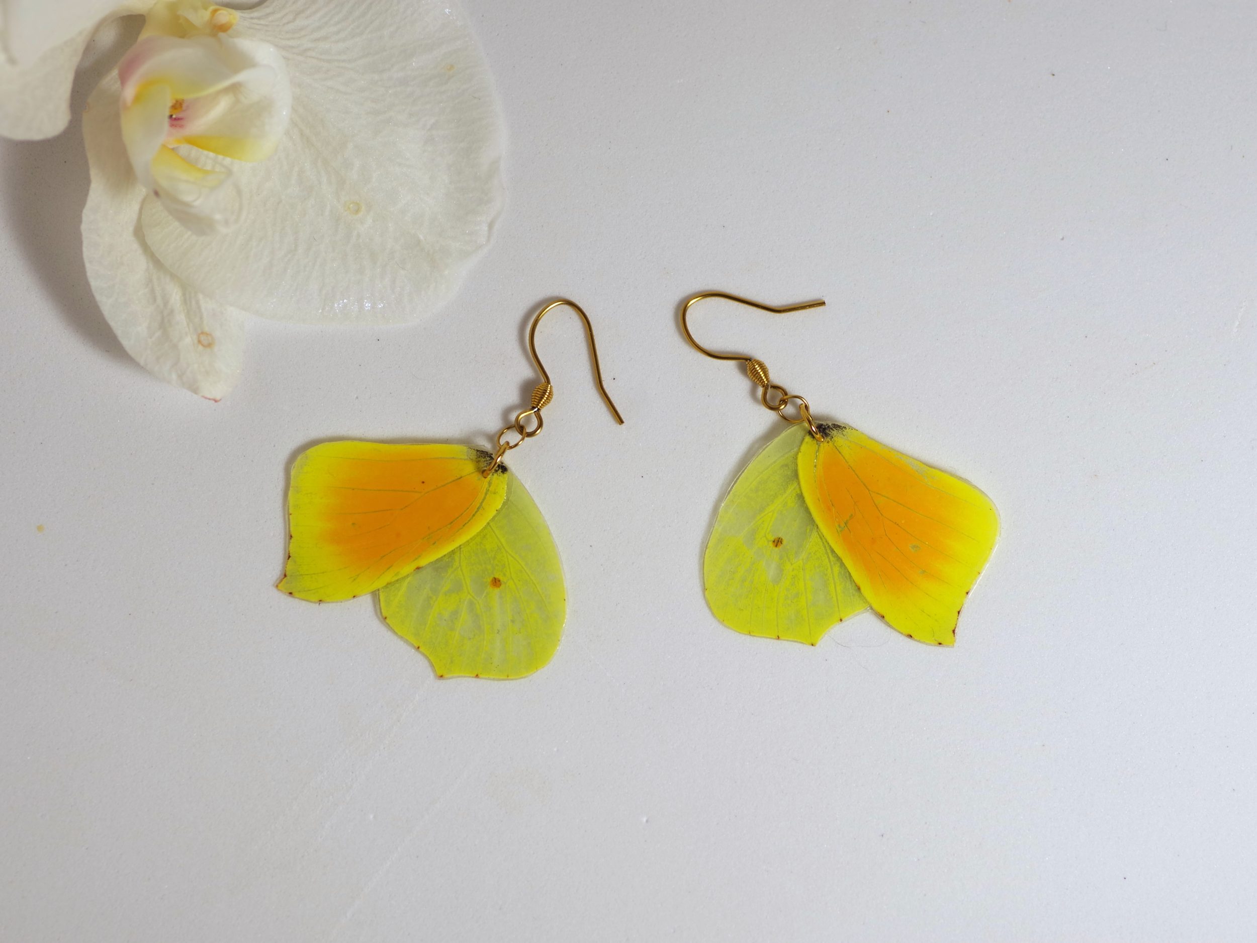 boucles d'oreilles réalisées avec des ailes de papillon orange et jaune, crochets dorés