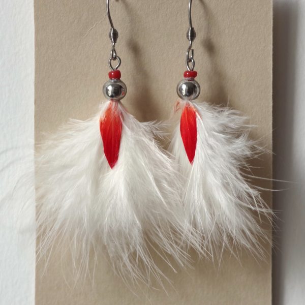 boucles d'oreilles rouge et blanc, plumes duveteuses blanches disposées en pompon, avec une petite plume rouge au milieu
