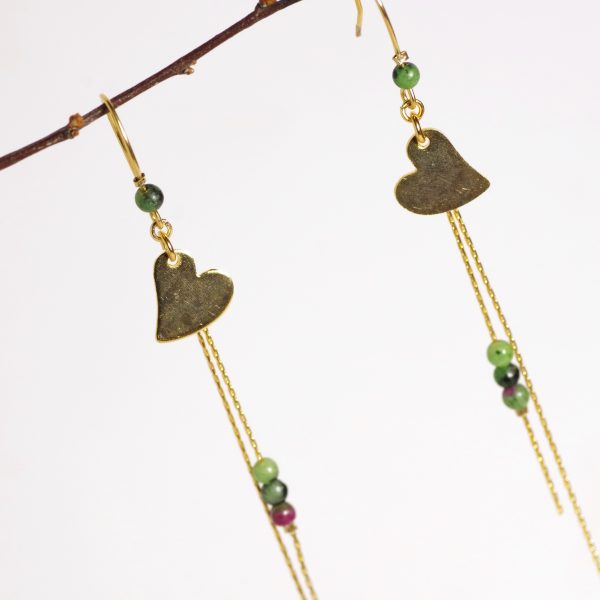 boucles d'oreilles avec un petit cœur doré et des petites perles sur une fine chaîne dorée.
