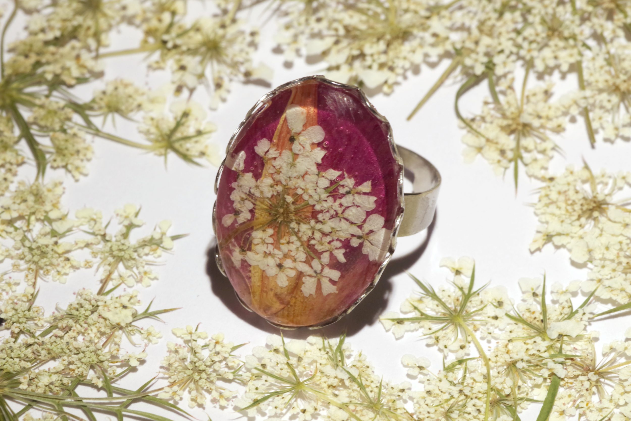 Grande bague ovale en verre, cabochon loupe sur une composition florale blanc rose et orange.
