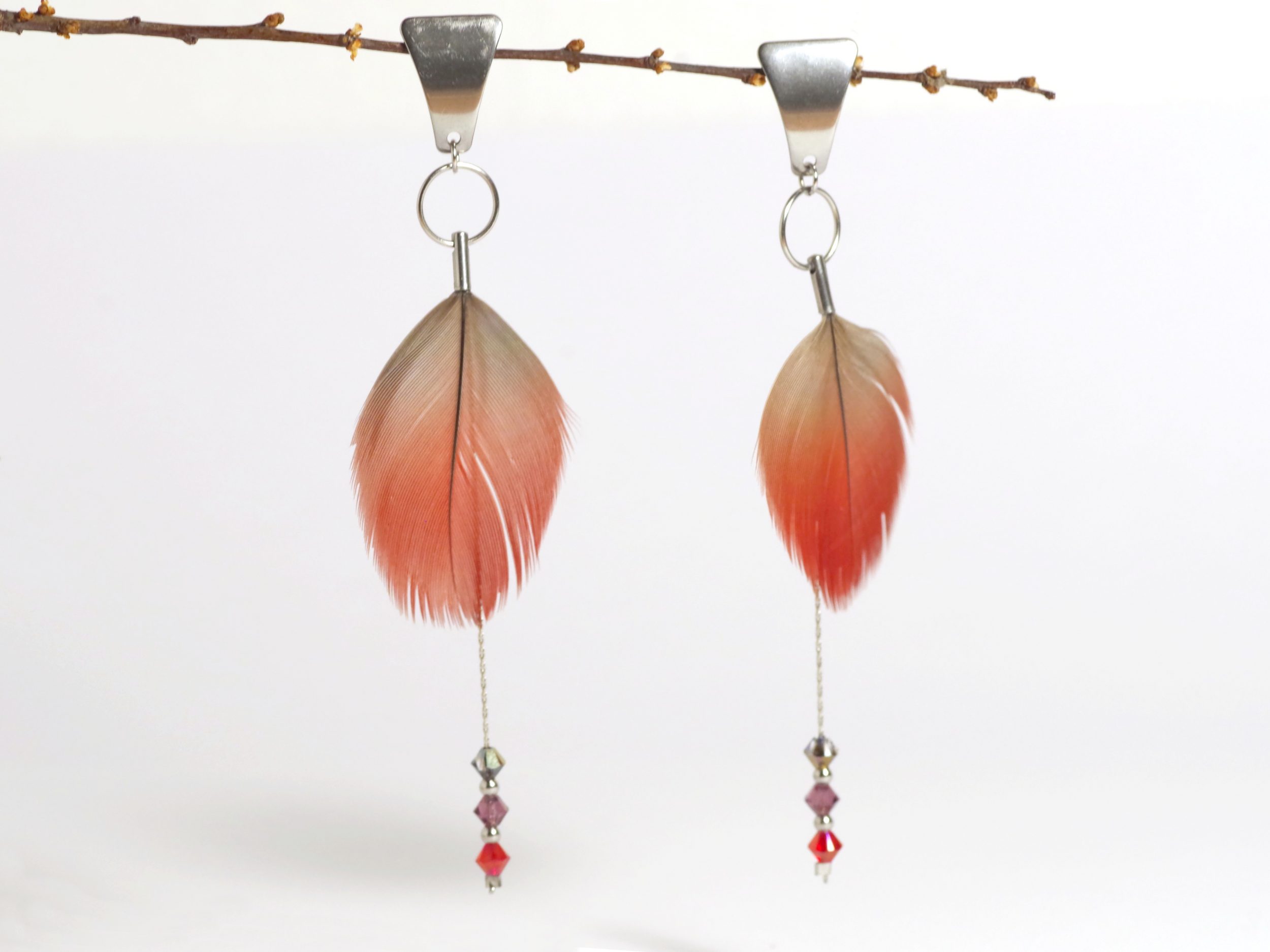 boucles d'oreilles en plumes rouges et chaînes inox avec des petites perles facettées assorties.