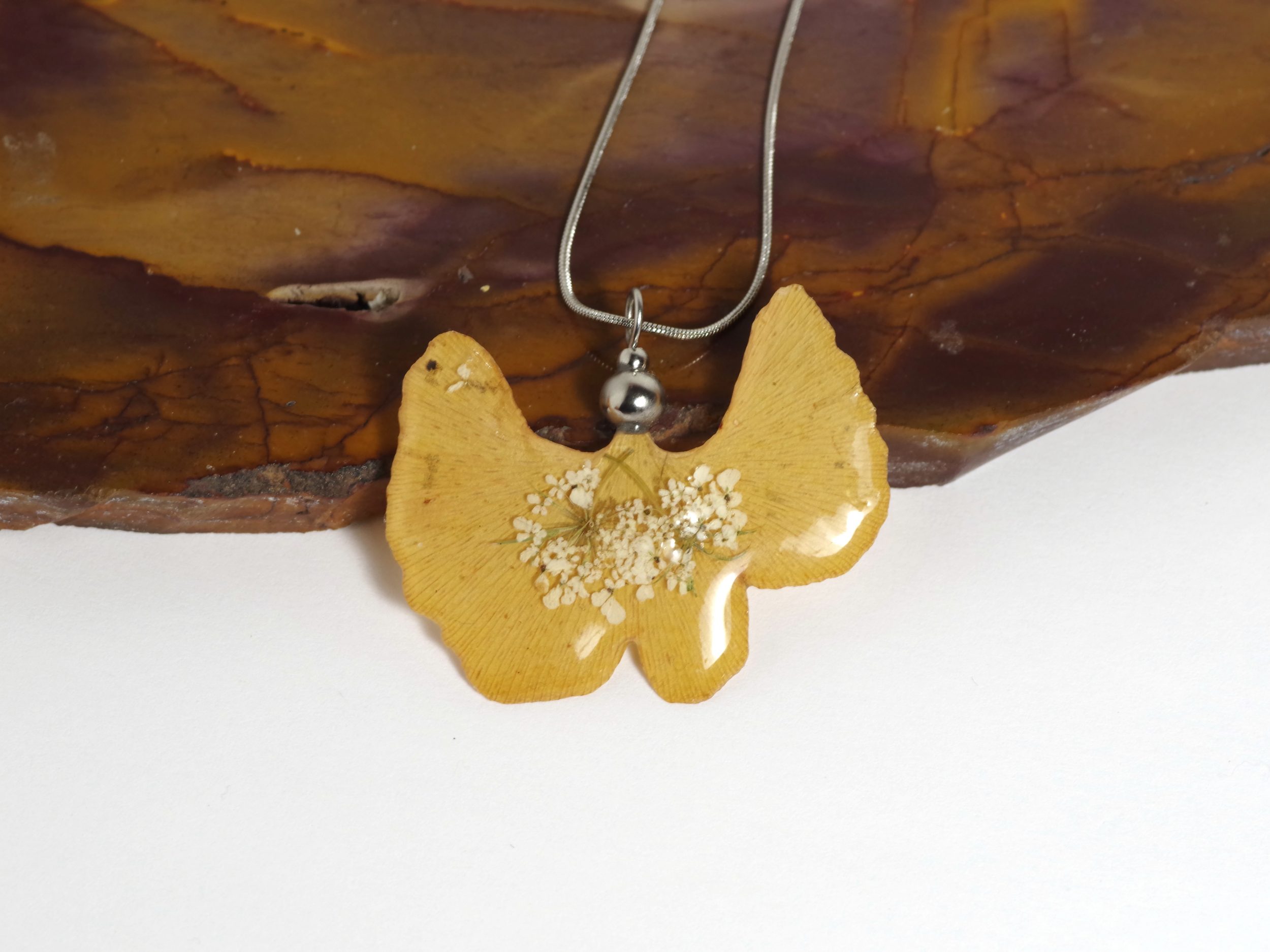 Pendentif lierre cristallisé : Très belle feuille de ginkgo jaune décorée de petites fleurs blanches. Sur une fine chaîne d'inox. Collier naturel et féminin.
