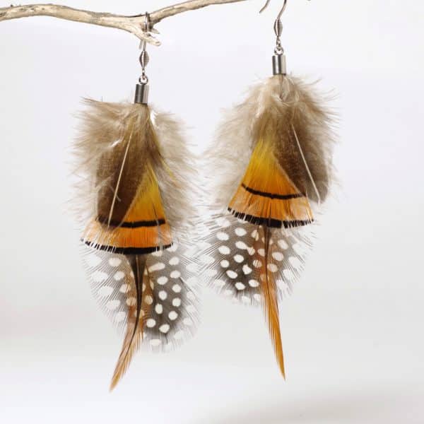 grandes boucles d'oreilles en plumes colorées et graphique, style nature sauvage. orange, brun et blanc
