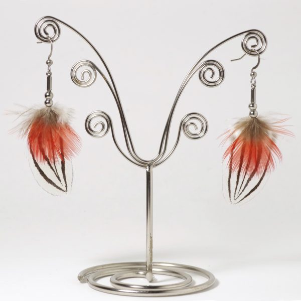 Une paire de boucles d'oreilles avec des plumes d'un rouge éclatant et des plumes blanches et noires