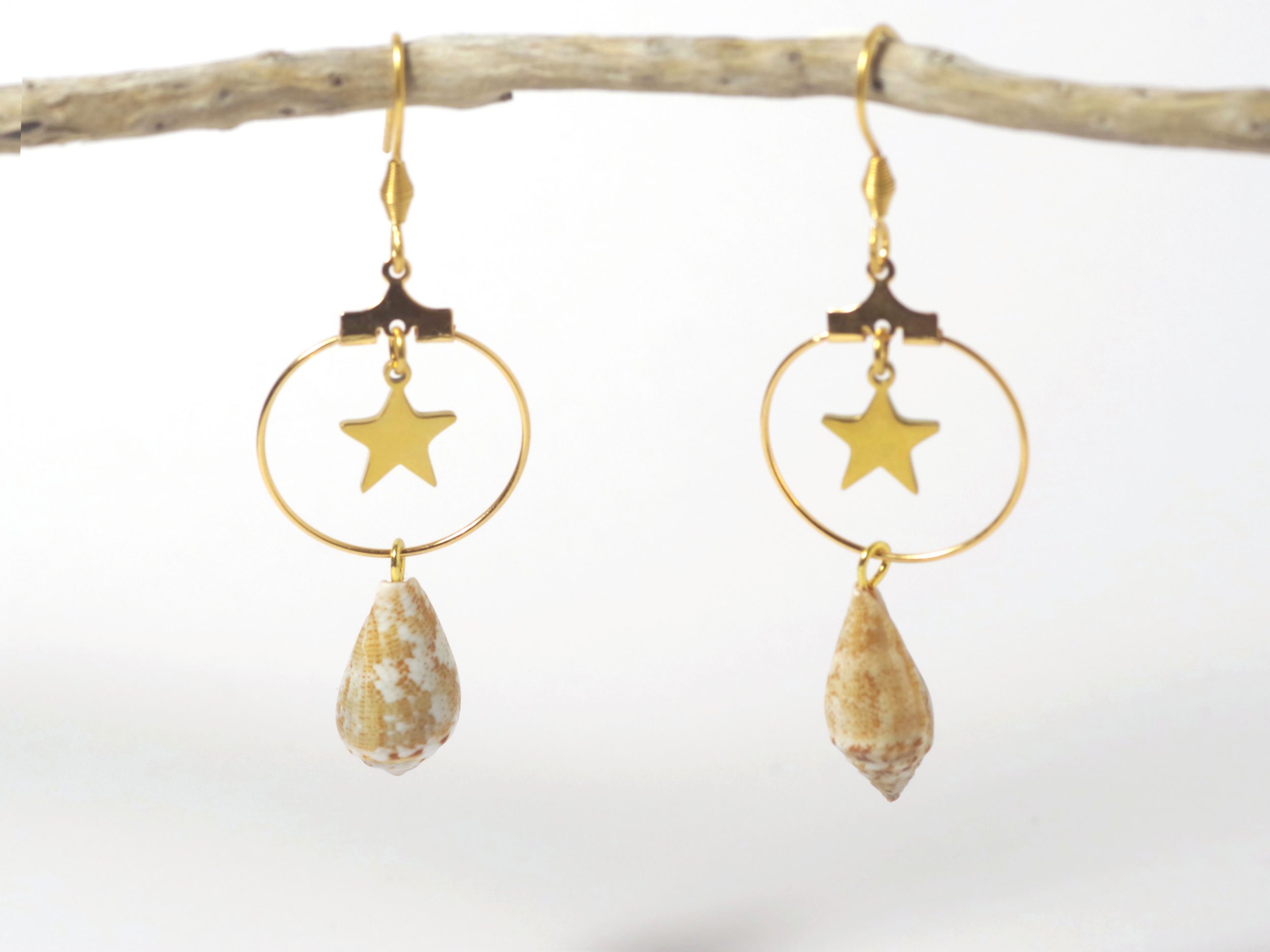 Boucles d'oreilles d'inspiration marine : étoile et coquillage en composition originale sur un anneau doré.