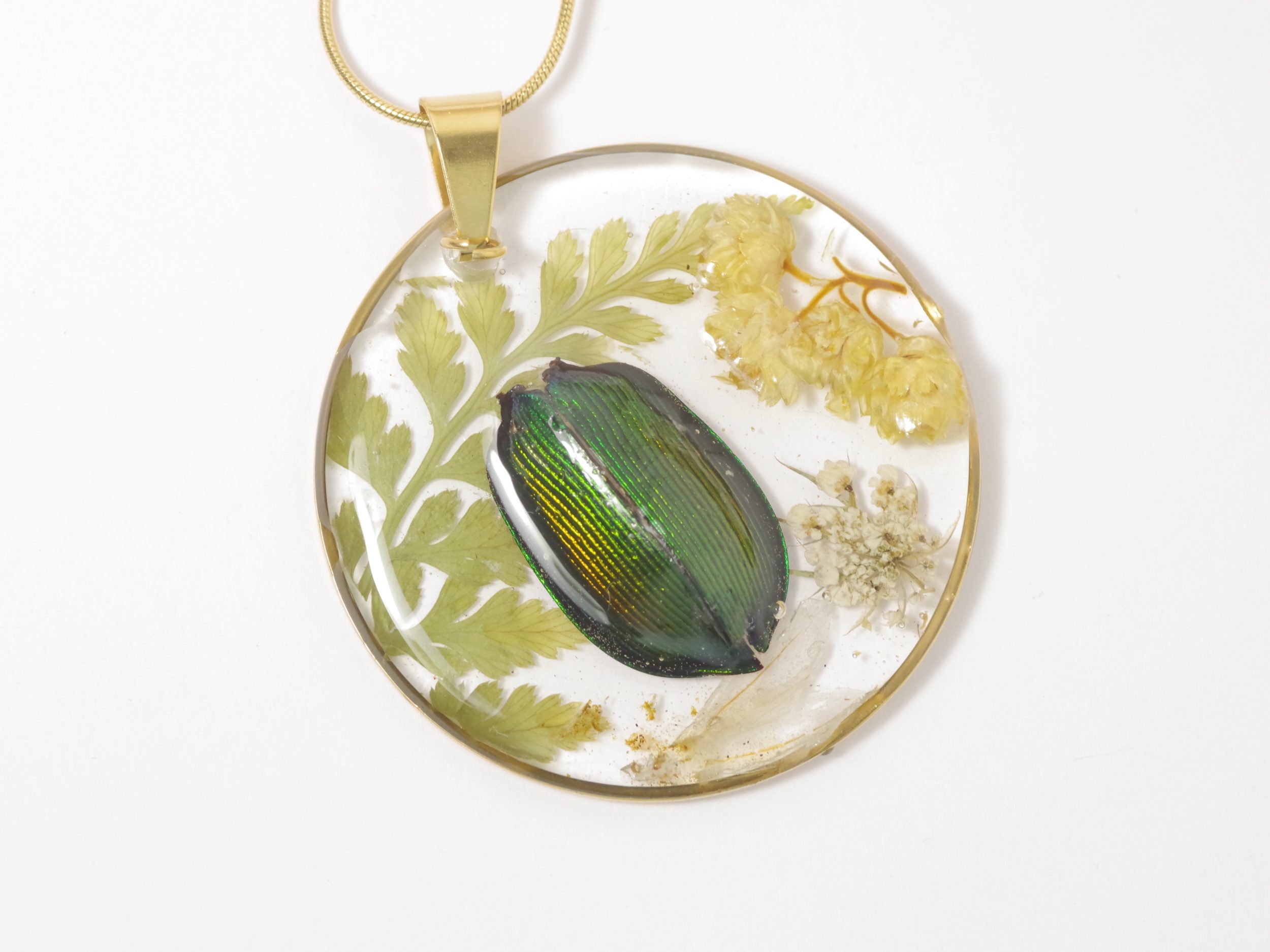 Pendentif nature : vrai scarabée et immortelles en inclusion dans une résine transparente.