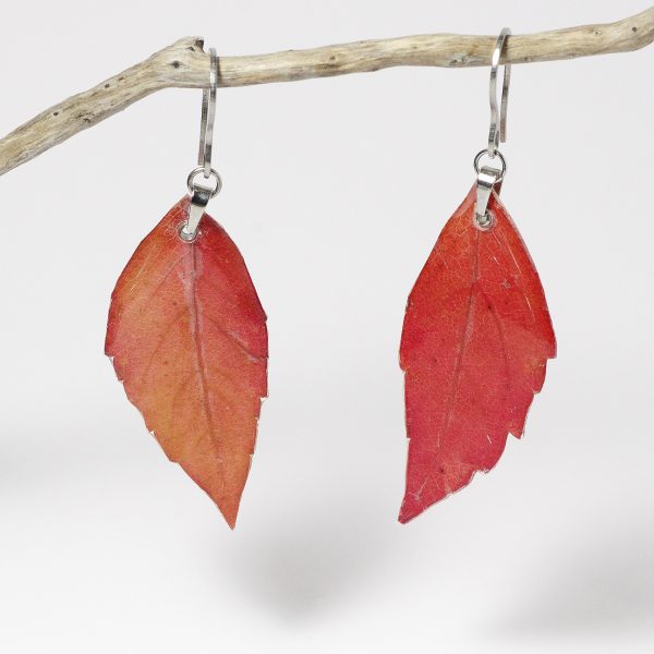 Boucles d'oreilles réalisées avec des feuilles rouges de vigne vierge glacées à la résine.