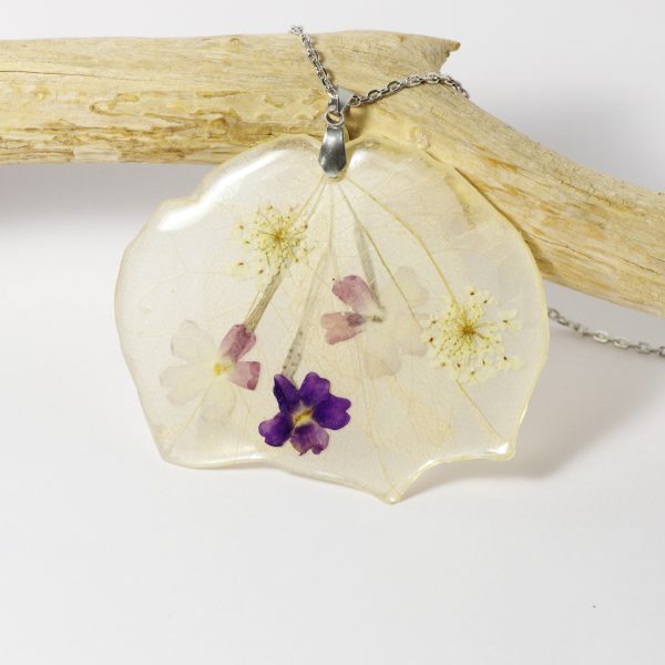 Un gros pendentif fleuri dans des tons très doux. composition florale glacée à la résine.