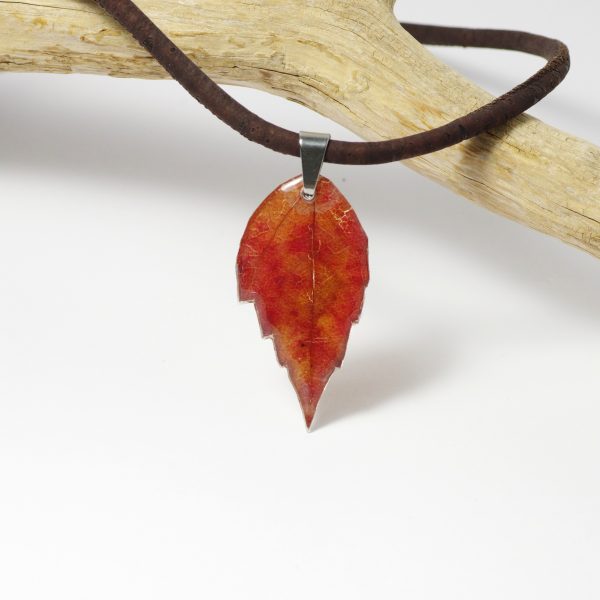Un beau camaïeu d'automne pour cette feuille de vigne vierge. Elle est glacée à la résine et montée en pendentif sur un cordon de liège.