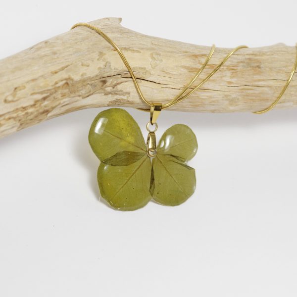 Un vrai trèfle à quatre feuilles glacé à la résine en pendentif sur une fine chaîne en inox doré.