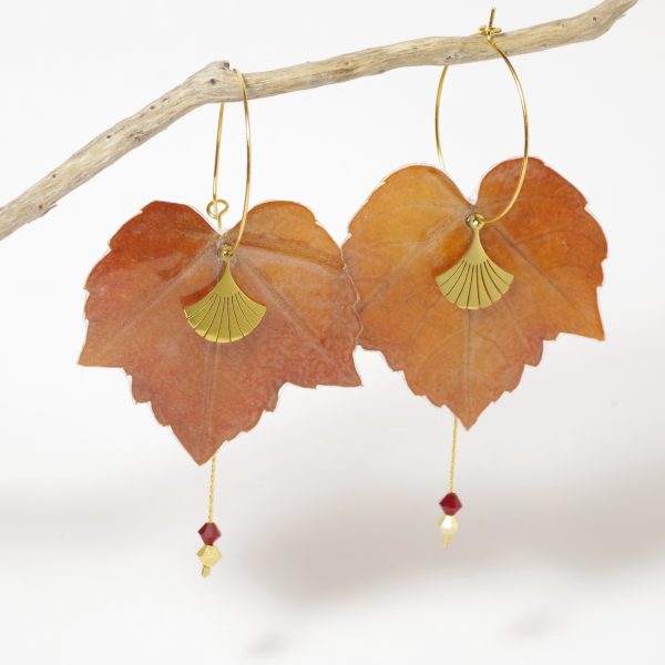 Feuilles d'automne de lierre rouge, montées en boucles d'oreilles avec une chaîne et deux petites perles sur des fines créoles dorées.