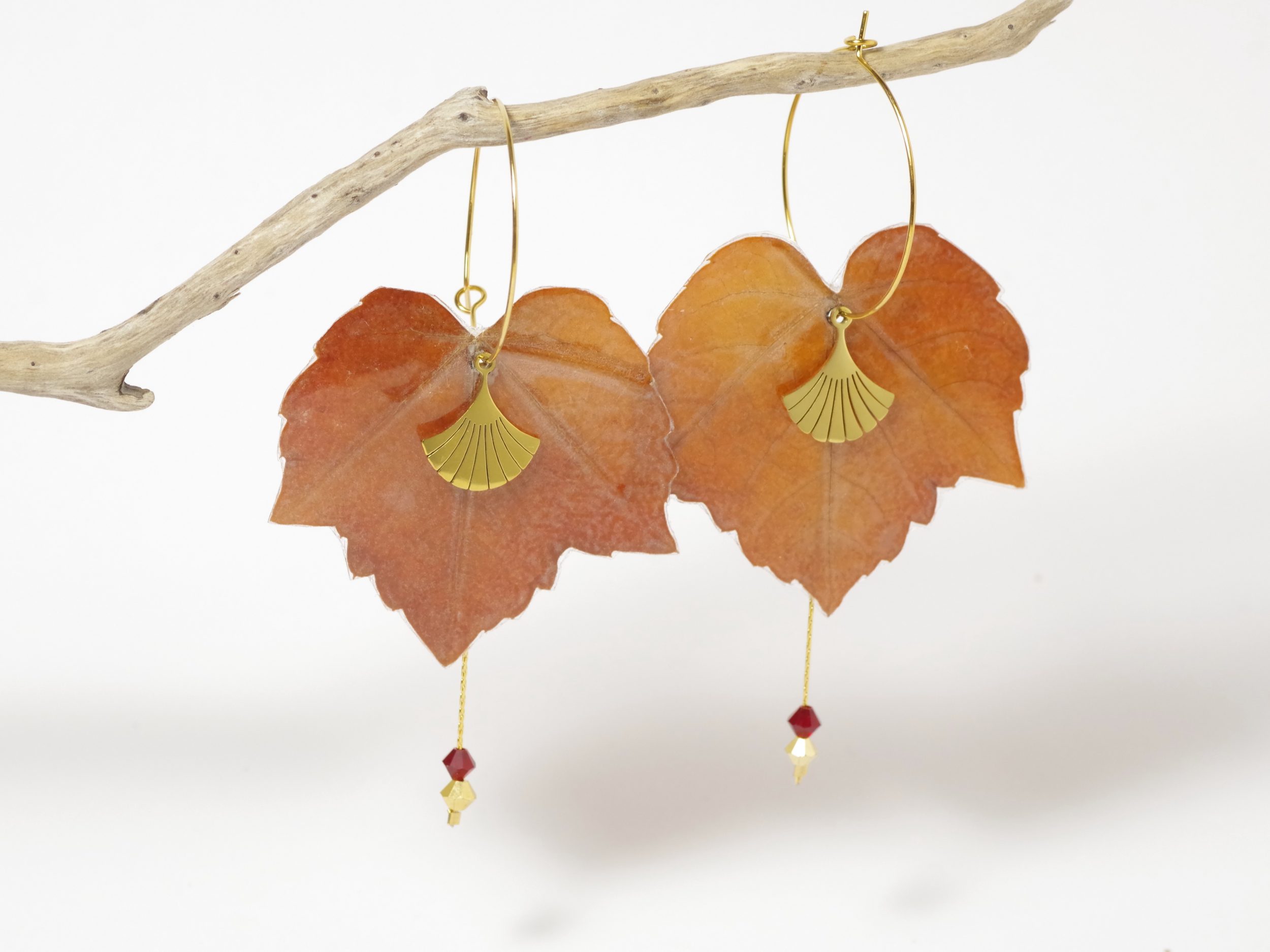 Feuilles d'automne de lierre rouge, montées en boucles d'oreilles avec une chaîne et deux petites perles sur des fines créoles dorées.