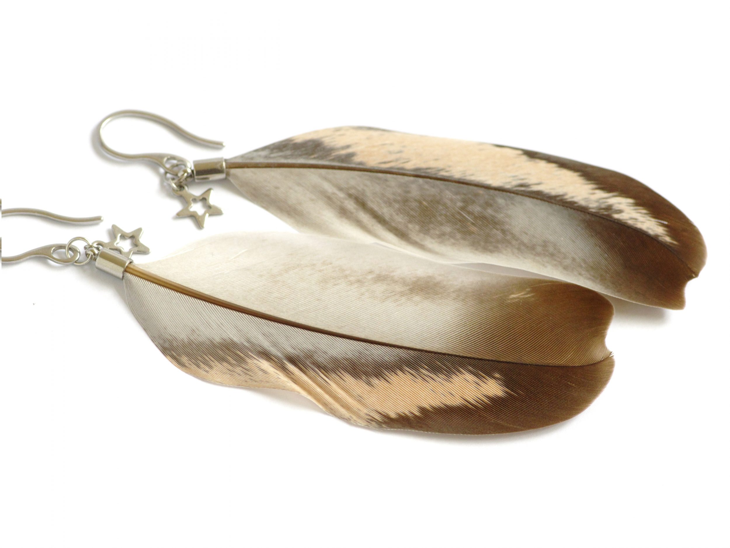 Belles plumes originales, de couleurs gris et nude, montées en boucles d'oreilles , simplement avec une petite étoile argentée.