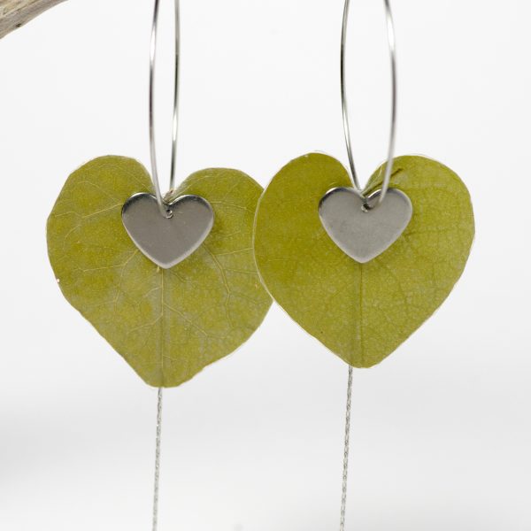 Des feuilles en forme de cœur sur des créoles en inox accompagnées de fines chaînes et cœurs.