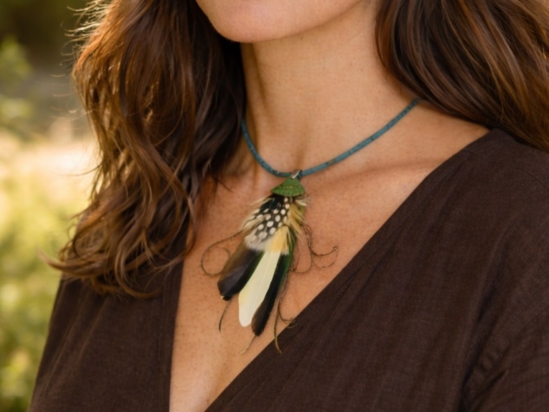 Pendentif réalisé avec une composition de plumes bleu-vert, sur un lacet de liège. Porté par un modèle créé par l'IA.
