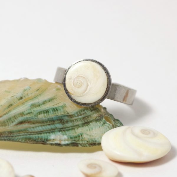 Un petit œil de sainte Lucie rond sur une bague fine en inox.