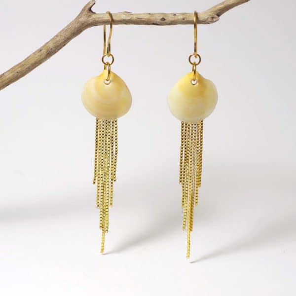 Boucles d'oreilles réalisées avec des coquillages jaunes et des chaînes dorées en cascade.