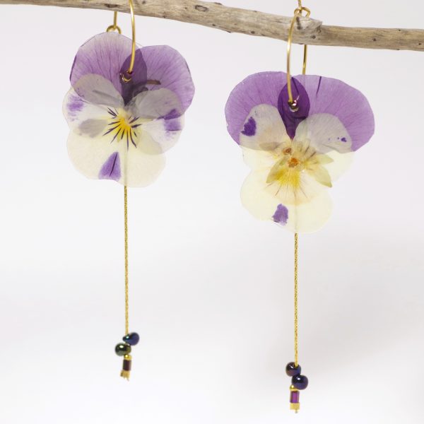 Pensées violet et blanc sur des petites créoles avec des chaînes dorées.