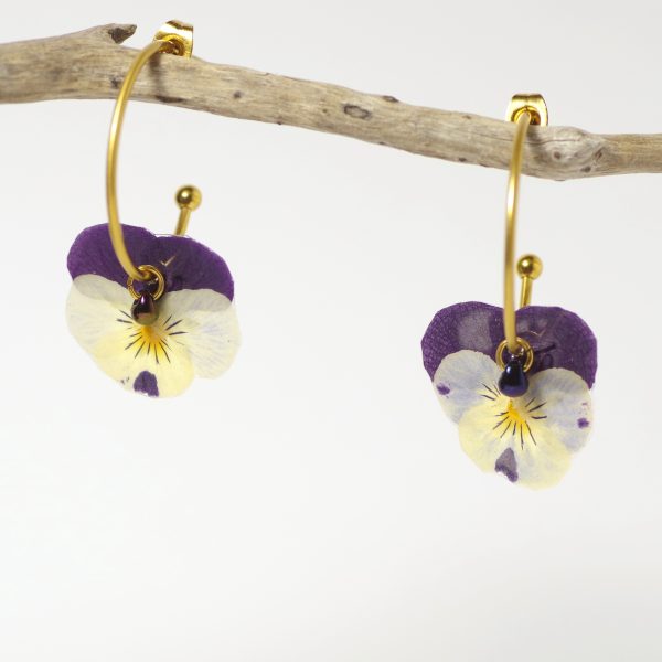 Minuscules pensées violettes et blanches sur des mini créoles dorées.