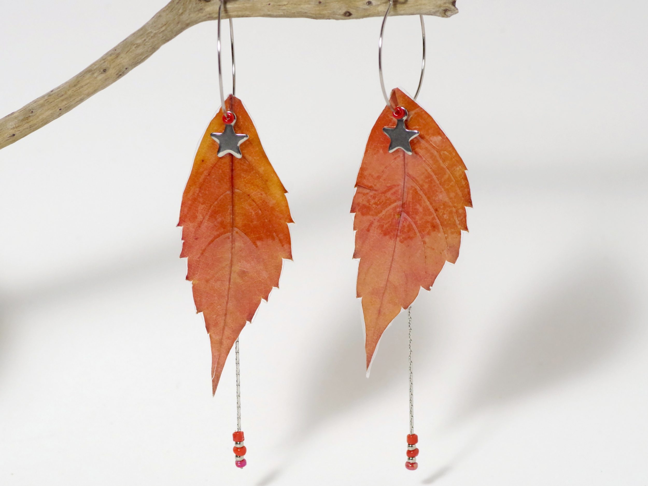 Des boucles d'oreilles créoles décorées de belles feuilles flammes.